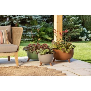 Trzy okrągłe doniczki t.b.t. w kolorze zielonym, beżowym i brązowym z roślinami na tarasie.