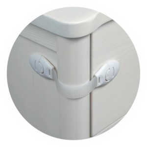 Białe zabezpieczenie szafki dla dzieci przymocowane do komody.