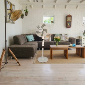 Biały wentylator stojący w salonie. Wentylator zapewnia świeże powietrze.