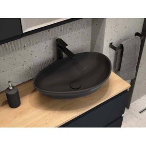 Czarna umywalka nablatowa na jasnym blacie w nowoczesnej łazience.