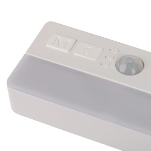 Zbliżenie: Biała lampa podszafkowa t.b.t. z czujnikiem i przełącznikami.