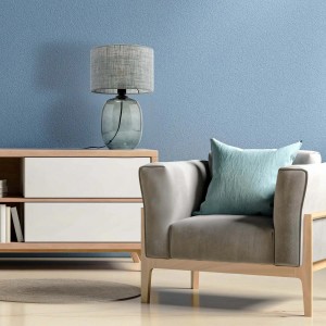 Dekoracyjna lampa stołowa t.b.t. z szarym abażurem na komodzie w salonie.