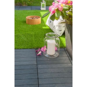 Ciemnoszare płytki tarasowe t.b.t. na patio z dekoracją i sztuczną trawą.