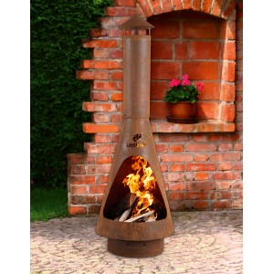 Palenisko t.b.t. w kolorze rdzy z palącym się drewnem na tle ceglanej ściany.