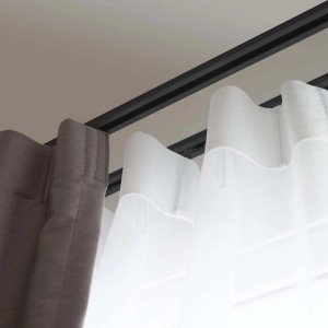 Karnisz z szarą i białą tkaniną zasłonową.