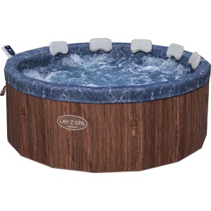 Okrągła, nadmuchiwana wanna z hydromasażem z niebieskim marmurkowym brzegiem i okładziną imitującą drewno.