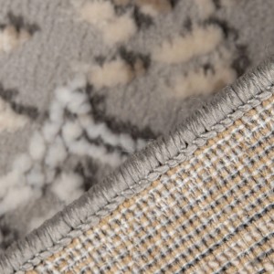 Zbliżenie szarego dywanu shaggy t.b.t. ze wzorem.