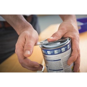 Otwieranie wiadra z farbą za pomocą narzędzia.