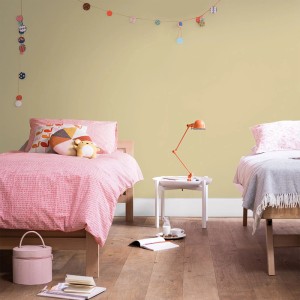Pokój dziecięcy z żółtą farbą na ścianach, dwa łóżka i lampa. Kolorowe farby do ścian dla pięknego domu.