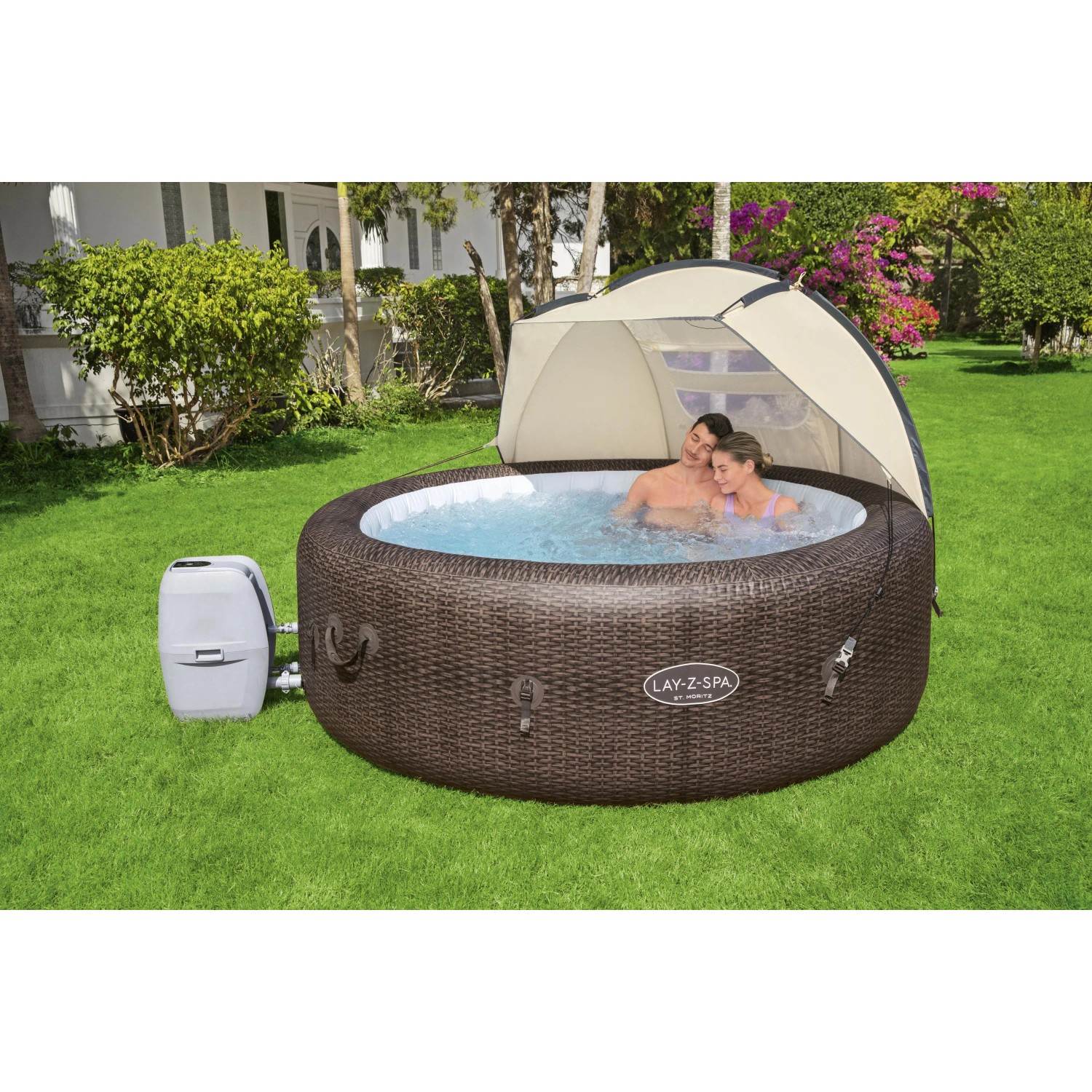 Osłona przeciwsłoneczna Bestway LAY-Z-SPA nad brązowym jacuzzi z parą w ogrodzie.
