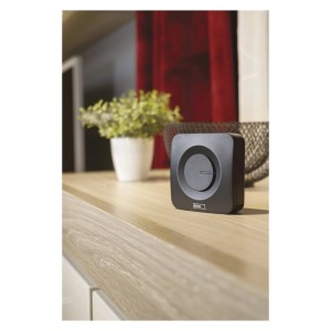 Czarny dzwonek t.b.t. na drewnianym stole. Dzwonek do drzwi wejściowych.