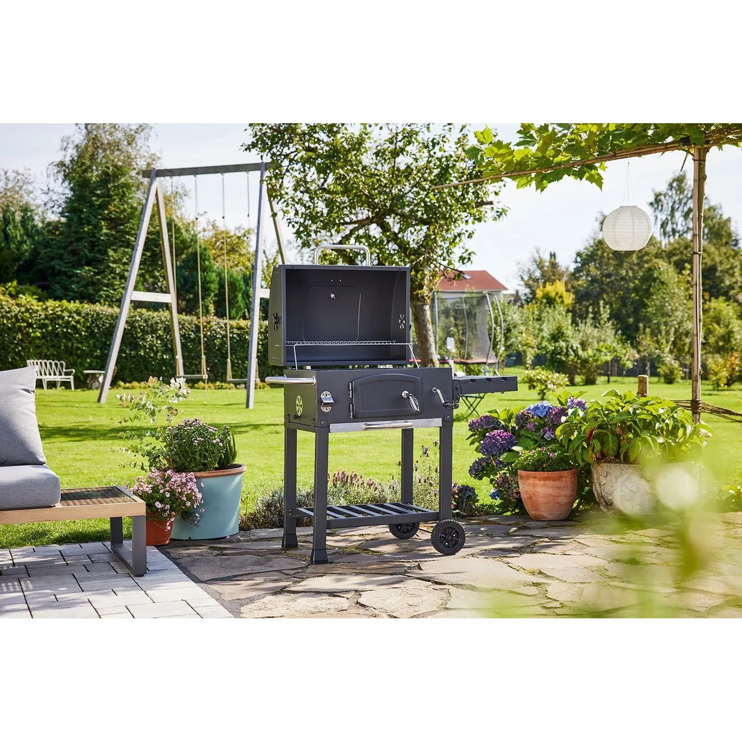 Grill węglowy Jamestown Jaxon z rusztem w ogrodzie, wózek grillowy z półką.