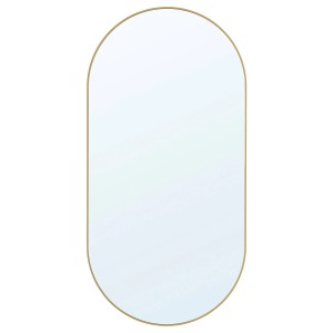 Owalne lustro t.b.t. ze złotą ramą do montażu na ścianie.