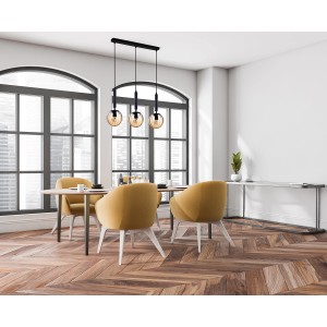 Nowoczesna lampa wisząca z trzema bursztynowymi szklanymi kulami nad stołem jadalnym.