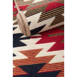Wzorzysty dywan t.b.t. z krótkim włosiem, czerwony, czarny i beżowy.
