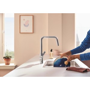 Zestaw baterii kuchennej Grohe Blue Pure Start z filtrem z węglem aktywnym w kolorze srebrnym podczas zmywania naczyń.