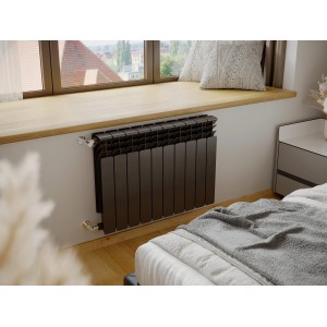 Brązowy grzejnik t.b.t. pod parapetem w sypialni.