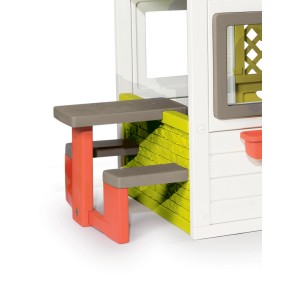 Zbliżenie domku zabaw z białym, szarym i pomarańczowym stołem i ławką.