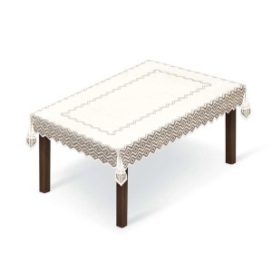 Beżowy stół z dekoracyjnym obrusem t.b.t. z geometrycznym wzorem i frędzlami.