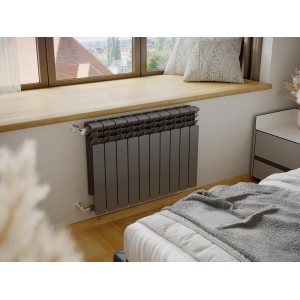 Szary grzejnik t.b.t. na ścianie w sypialni. Ogrzewanie dla przytulnego ciepła.