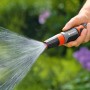 Opryskiwacz czyszczący Gardena w akcji: strumień wody w ogrodzie.