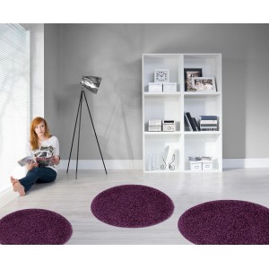 Fioletowy, owalny dywan z długim włosiem w salonie.