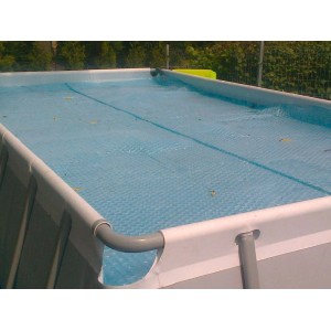Prostokątna pokrywa basenowa, niebieska folia bąbelkowa na basenie.