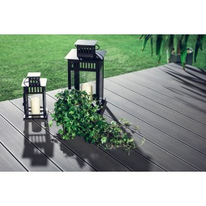 Szare deski tarasowe t.b.t. z dekoracyjnymi lampionami i zieloną rośliną na tarasie.