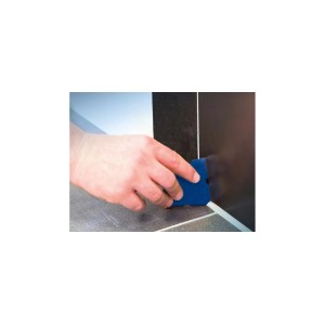 Ręka używa niebieskiej kielni do spoinowania do wygładzania spoin. Narzędzie dla glazurników.