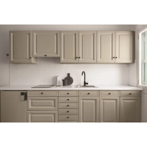 Jasna kuchnia z szafkami kuchennymi i zlewem na tle białych płytek.