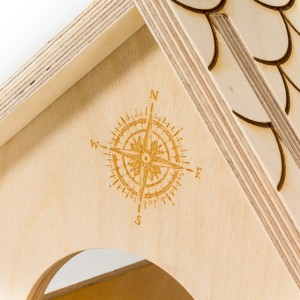 Zbliżenie drewnianego karmnika dla ptaków t.b.t. z motywem kompasu.