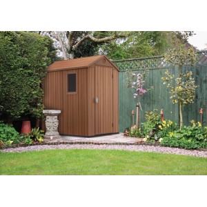 Brązowy plastikowy domek narzędziowy t.b.t. w ogrodzie.