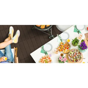 Taras z brązowymi podestami t.b.t., grillem i nakrytym stołem na przyjęcie w ogrodzie.