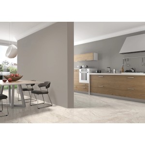 Jasny pokój z płytkami podłogowymi t.b.t. imitującymi marmur. Jadalnia i kuchnia w tle.