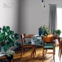 Salon z szarą farbą do ścian t.b.t. Jadalnia z drewnianym stołem i roślinami.