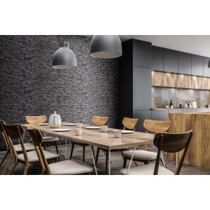 Stół jadalny przed ścianą z ciemnymi kamieniami dekoracyjnymi t.b.t. i nowoczesną kuchnią.