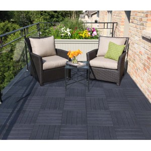 Taras z ciemnymi płytkami podestowymi t.b.t., dwoma fotelami i stołem. Idealny na balkon i do ogrodu.