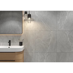 Szare płytki podłogowe w łazience z umywalką i lustrem.