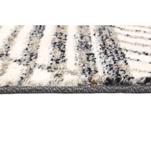Zbliżenie dywanu w paski w kolorze białym, szarym i czarnym.