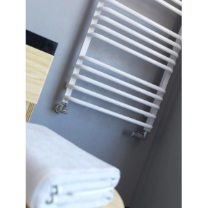 Biały grzejnik t.b.t. w łazience z ręcznikiem.