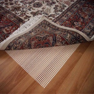 t.b.t. Mata antypoślizgowa pod dywanem na drewnianej podłodze.