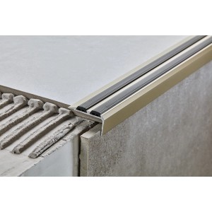 Zbliżenie beżowego profilu schodowego z paskami antypoślizgowymi.