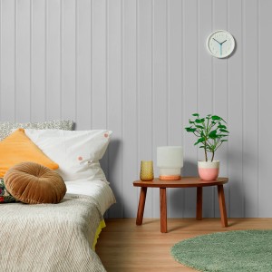 Przestrzeń mieszkalna z szarą farbą ścienną, łóżkiem i stołem z dekoracją. Emalie kolorowe.