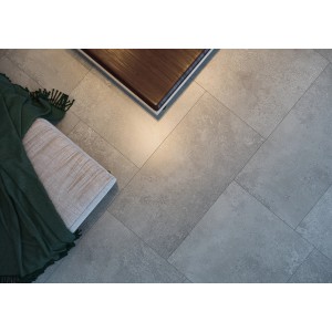 Szare płytki podłogowe t.b.t. ułożone z elementami dekoracyjnymi. Idealne do nowoczesnego wnętrza.