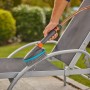 Gardena Cleansystem Szczotka ręczna Soft M z przyłączem węża w użyciu do czyszczenia leżaka ogrodowego.
