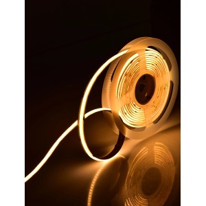 Zwinięta, ciepła biała taśma LED na przezroczystej szpuli.