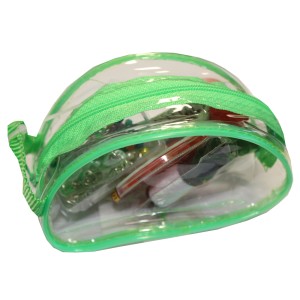 Zestaw akcesoriów do szycia w przezroczystej torbie z zielonym zamkiem.