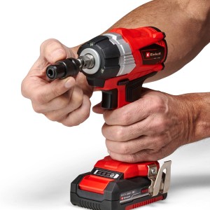Klucz udarowy akumulatorowy Einhell Power X-Change TP-CW 18 Li BL-Solo z adapterem bitów w dłoni.