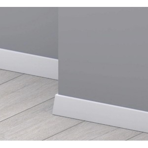 Białe listwy przypodłogowe t.b.t. na szarej ścianie i jasnej drewnianej podłodze.