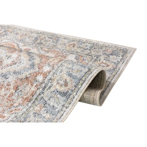 Zbliżenie dywanu z krótkim włosiem we wzory kwiatowe w kolorze szarym, beżowym i pomarańczowym.